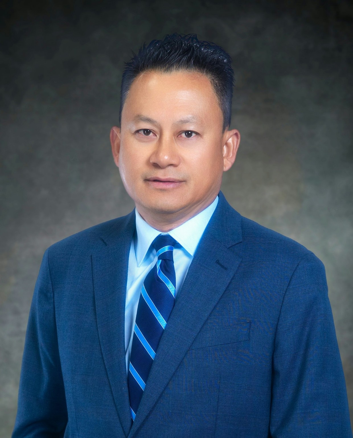 Mark Nguyen in a blue suit and striped tie